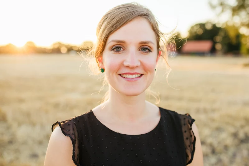 Frau im Abendlicht auf einem Feld – Gegen die Sonne fotografieren